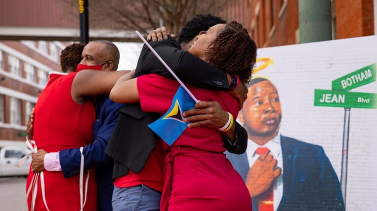The family of Botham Jean hug after unveiling the street...