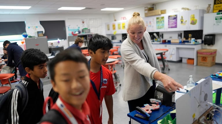 Middle school science teacher Vanessa Stevenson, right, talks with students...