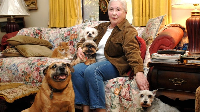 Janet Brasco surrounded by her four dogs and a cat...