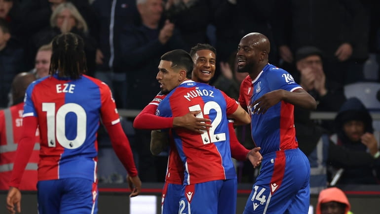 Crystal Palace's Michael Olise, centre, celebrates with teammates after scoring...