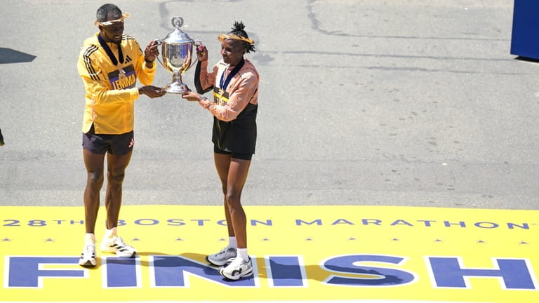 Boston Marathon men's division winner Sisay Lemma, of Ethiopia, left,...