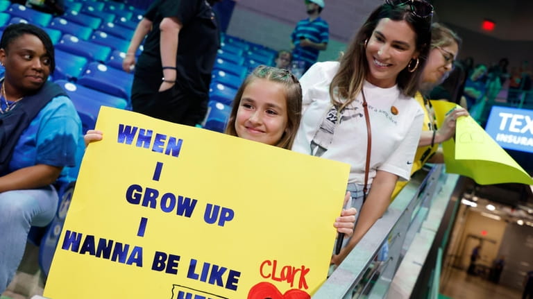 Pailynn Amos, center, holds a sign for Indiana Fever guard...