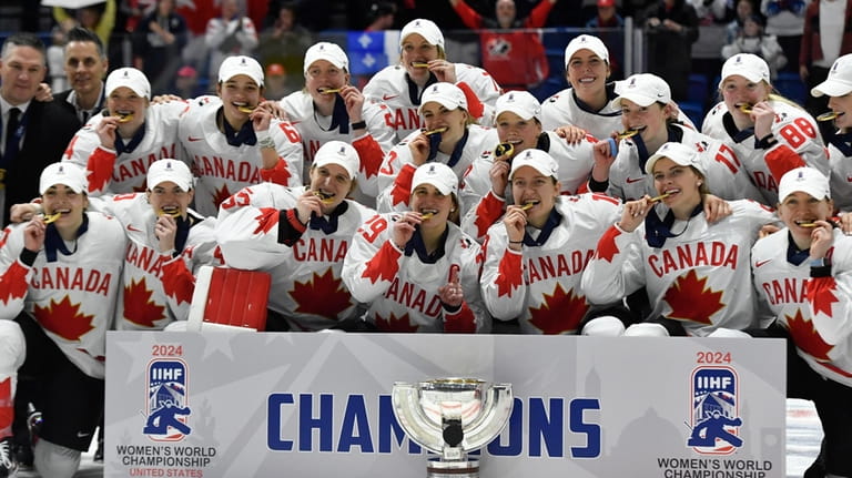 Team Canada players pose with their gold medals and the...