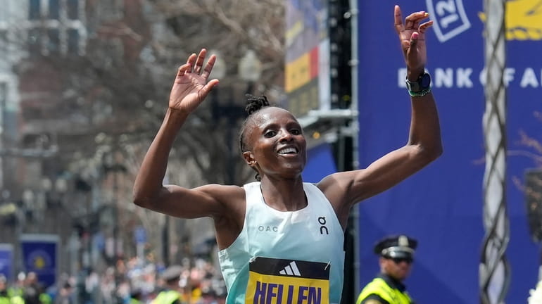 Hellen Obiri, of Kenya, celebrates after crossing the finish line...