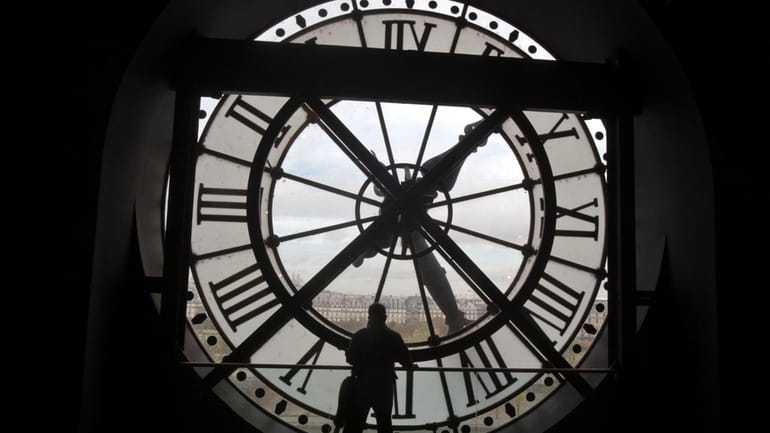 A visitor looks through the clock of the Orsay museum,...