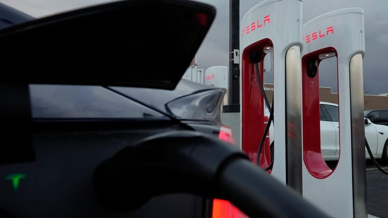 A vehicle charges at a Tesla Supercharger station in Detroit,...