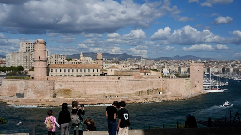 People stand in the gardens overlooking the Old Port, in...