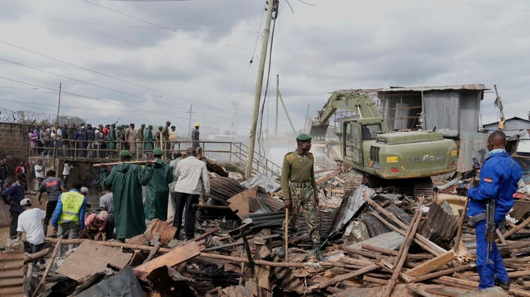 A bulldozer demolishes houses on riparian land in the Mukuru...