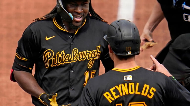 Pittsburgh Pirates' Oneil Cruz, left, is greeted by Bryan Reynolds...