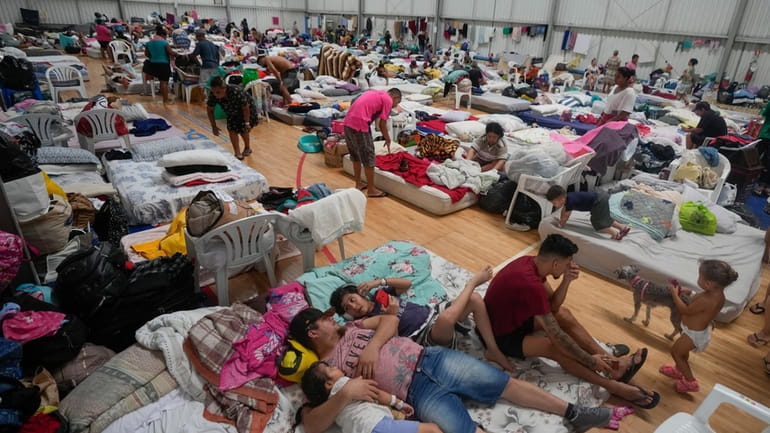 People who evacuated their flooded homes rest in a shelter...