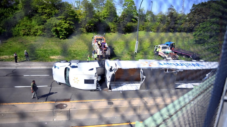 A Walmart tractor-trailer truck on its side after striking an overpass Wednesday...