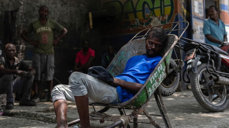 A man naps in a wheelbarrow in Port-au-Prince, Haiti, Sunday,...