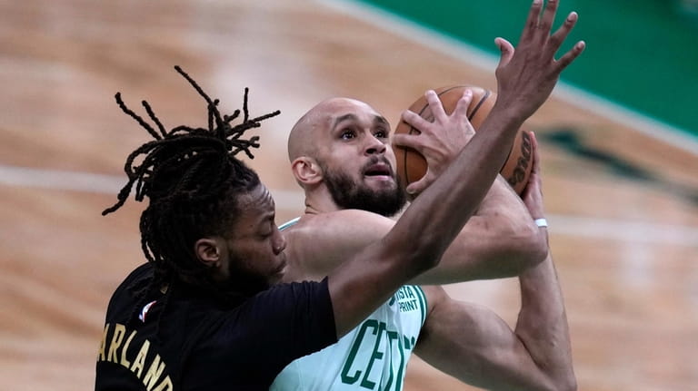 Boston Celtics guard Derrick White is pressured by Cleveland Cavaliers...