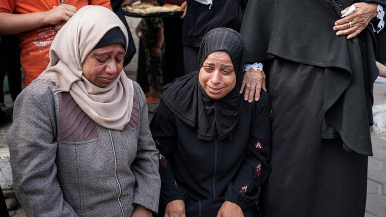 Mourners react next to the bodies of Palestinians who were...