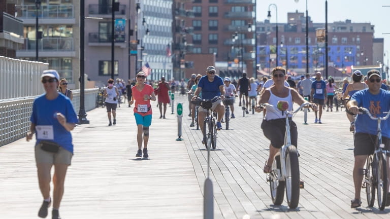 Runners and bikers on the boardwalk on Monday, July 4,...