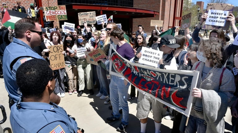 Protesters face off against police officers at the University of Massachusetts...