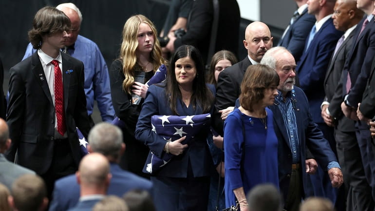 Kelly Weeks, center, the widow of slain Deputy U.S. Marshal...
