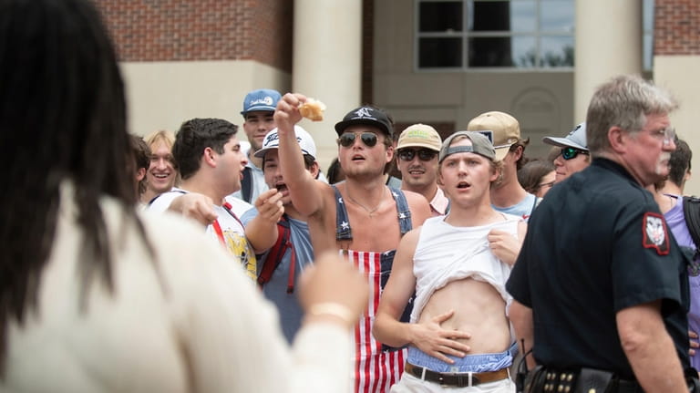 University of Mississippi student and counter-protester Connor Moore, center, taunts...