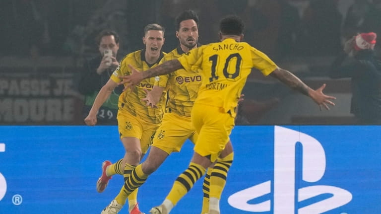 Dortmund's Mats Hummels, center, celebrates after scoring his side's opening...