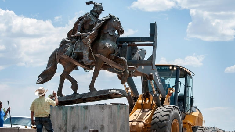 Rio Arriba County workers remove the bronze statue of Spanish...