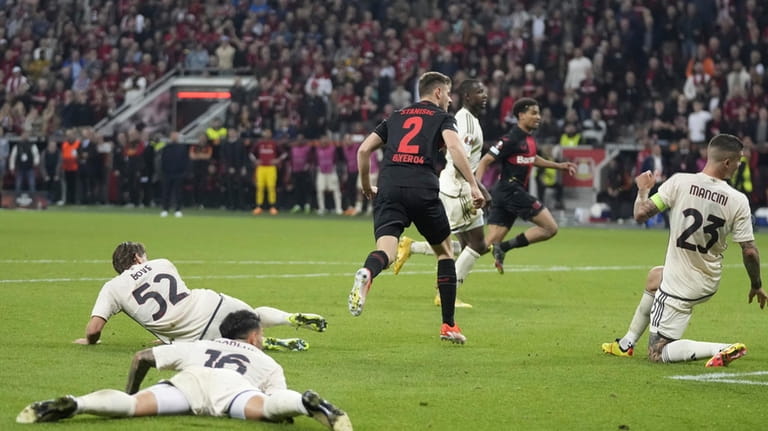 Leverkusen's Josip Stanisic, centre, scores during the Europa League second...