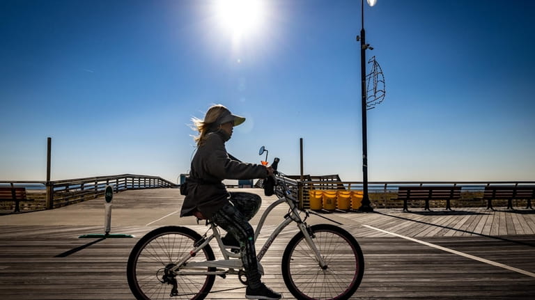 A woman riding her bike on the sunny side of...