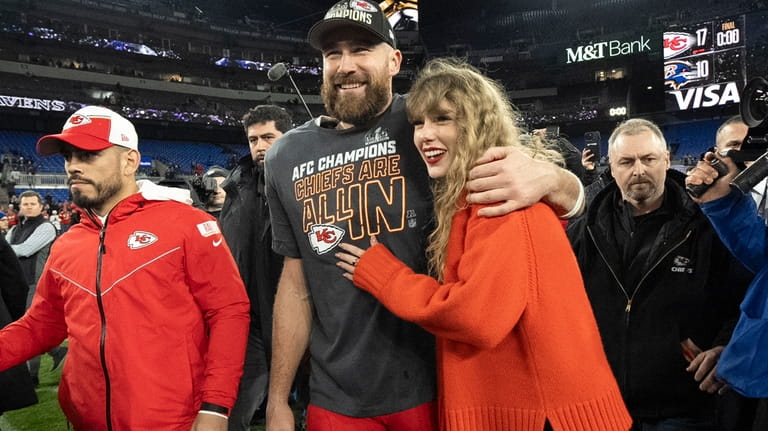 Kansas City Chiefs tight end Travis Kelce walks with Taylor...