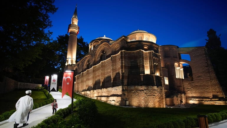 A Muslim cleric walks along a former Byzantine church which...