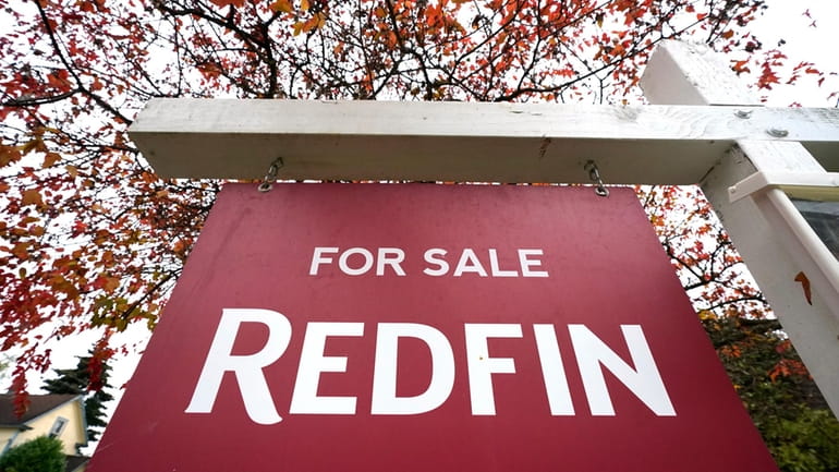 A Redfin "for sale" sign stands in front of a...