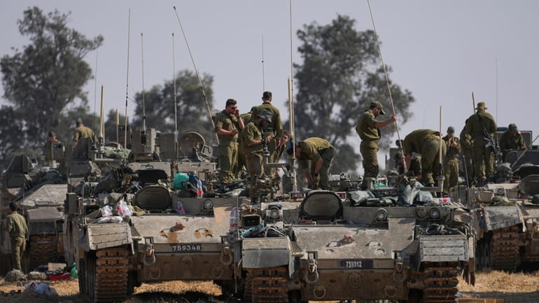 Israeli soldiers are seen at a staging ground near the...