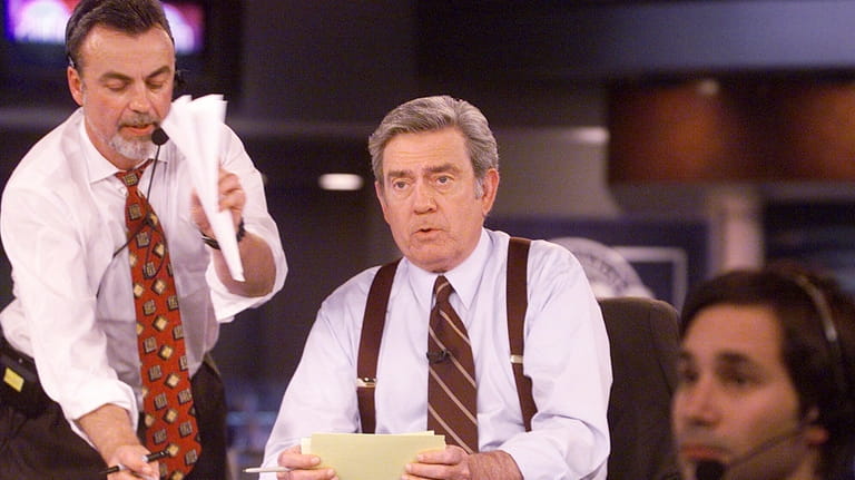 CBS News anchor Dan Rather reads from cue cards during...