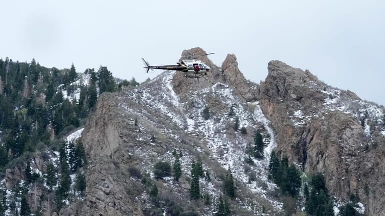 A Utah Department of Public Safety helicopter carries rescuers from...