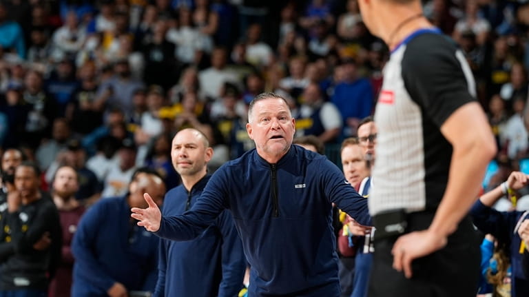 Denver Nuggets head coach Michael Malone, center, argues for a...