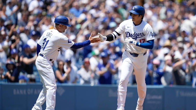 Los Angeles Dodgers designated hitter Shohei Ohtani celebrates with third...