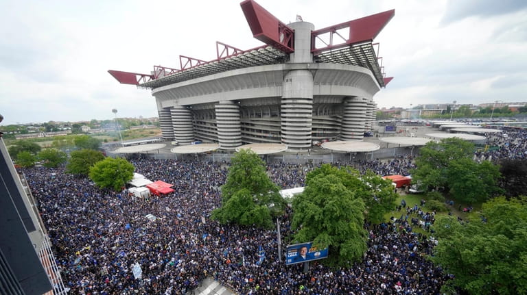 A crowd of fans wait outside the San Siro Stadium...