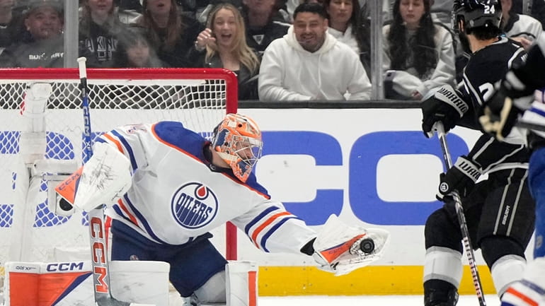 Edmonton Oilers goaltender Stuart Skinner, left, makes a glove save...