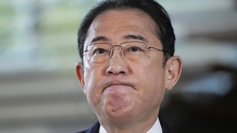 Japan's Prime Minister Fumio Kishida speaks to reporters at his...