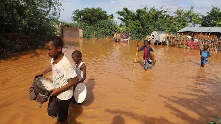 Children flee floodwaters that wreaked havoc at Mororo, border of...