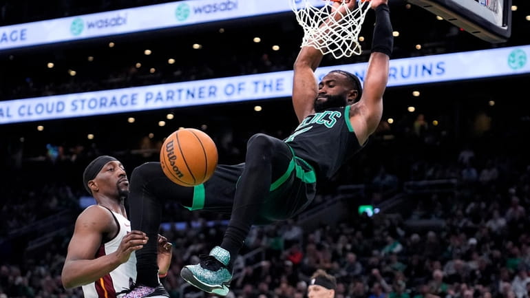 Boston Celtics guard Jaylen Brown, right, slams a dunk against...