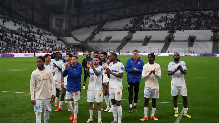 Marseille players celebrate after defeating Lens in a French League...