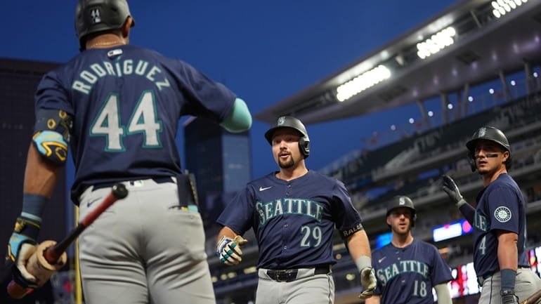 Seattle Mariners' Cal Raleigh (29) celebrates with teammates after hitting...