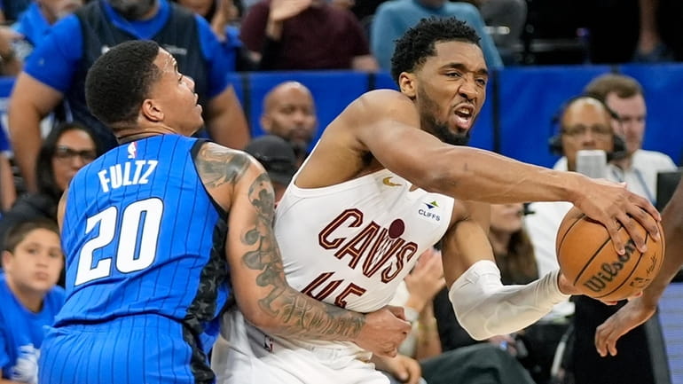 Cleveland Cavaliers guard Donovan Mitchell is fouled by Orlando Magic...
