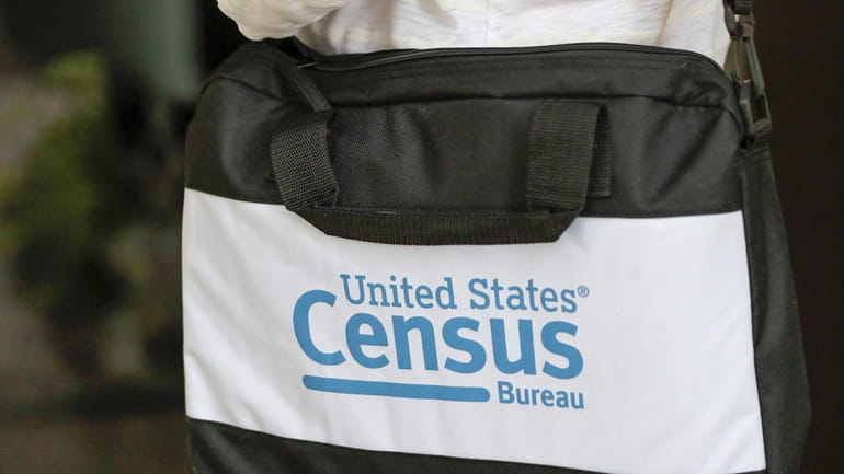 The briefcase of a census taker is seen as she...
