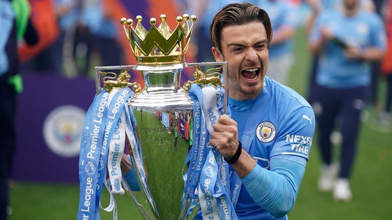 Manchester City's Jack Grealish celebrates with the trophy after winning...