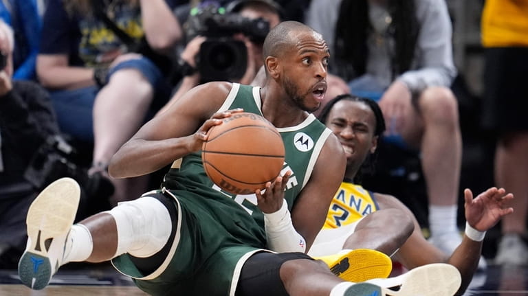 Milwaukee Bucks' Khris Middleton is defended by Indiana Pacers' Aaron...