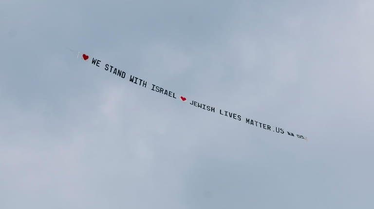 A plane bearing a banner that reads ""We stand with...