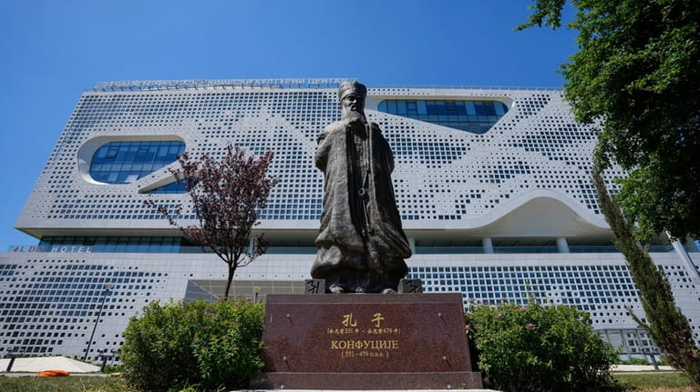 A statue of ancient Chinese philosopher Confucius stands in front...