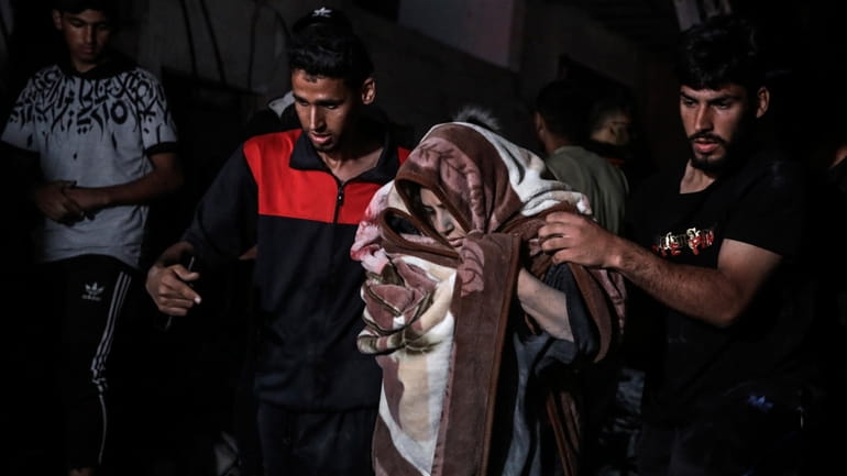 Palestinians rescue a woman survived after the Israeli bombardment on...