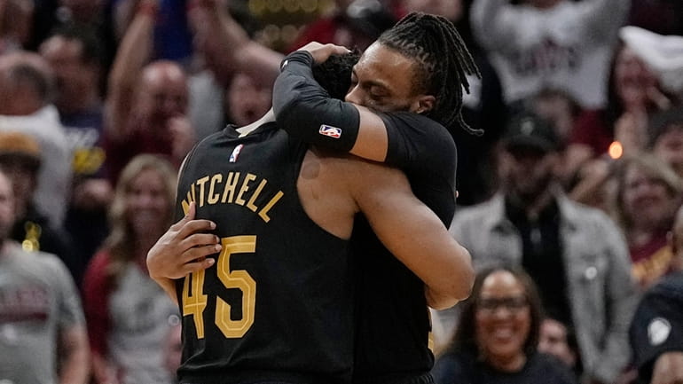 Cleveland Cavaliers guard Darius Garland, right, hugs teammate Donovan Mitchell...