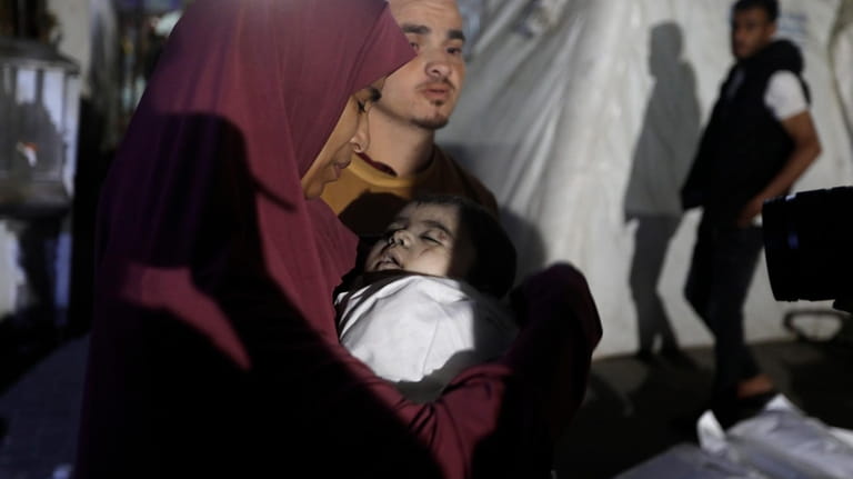 A Palestinian woman mourns her relative, 7-month old baby Hani...